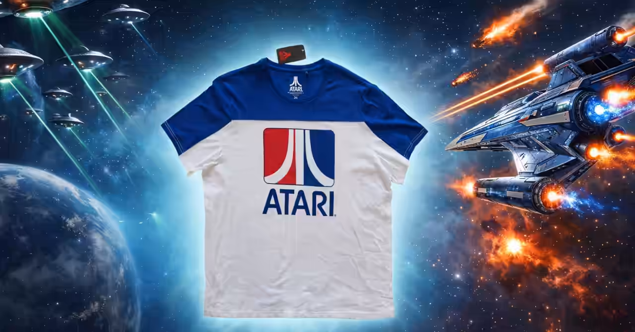 Composite widescreen illustration showing an Atari T-shirt floating at the centre of a space battle, with alien saucers attacking from the left and an Earth defender spaceship firing back from the right.