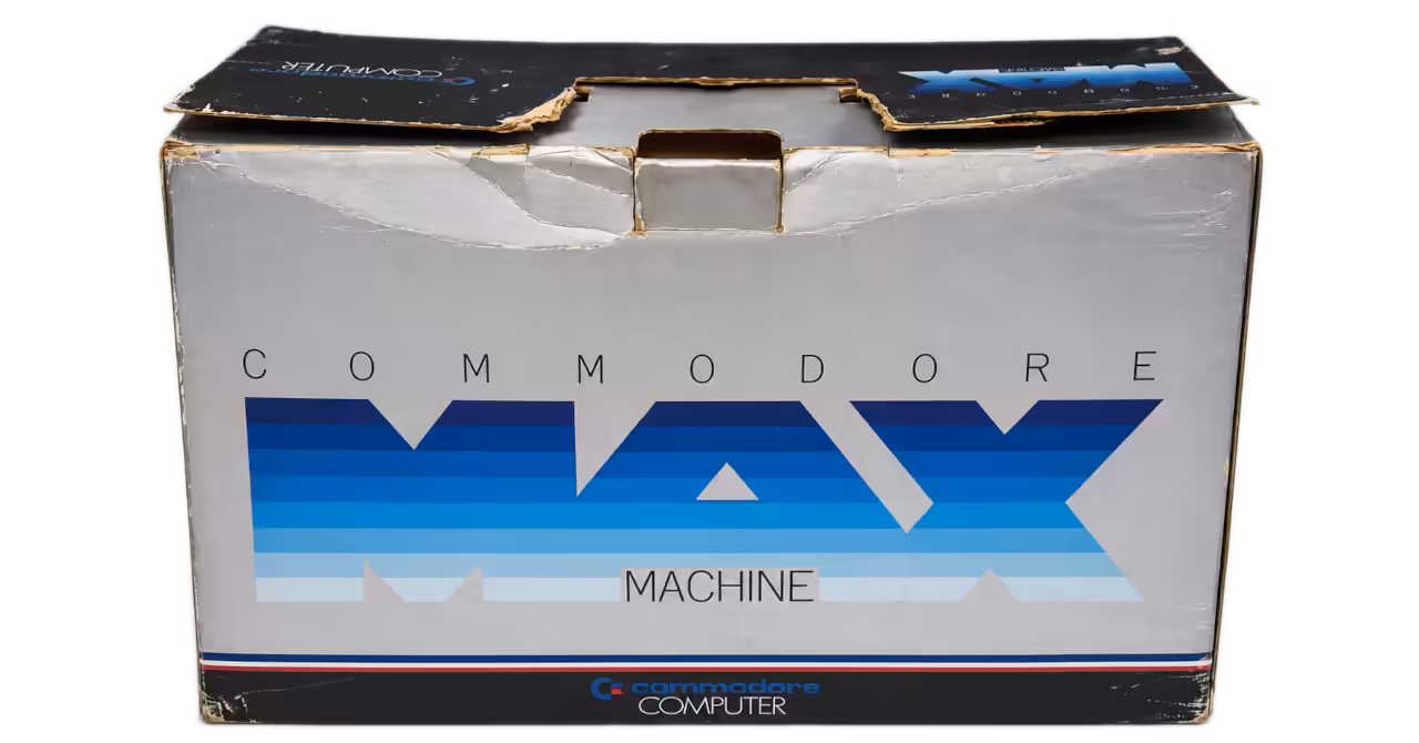 Rear side of a worn Commodore MAX Machine retail box showing the large blue MAX logo, Commodore branding and damaged packaging flaps.