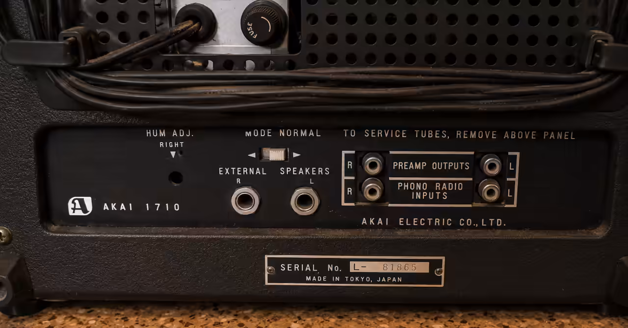 Rear panel of an AKAI 1710 reel-to-reel tape recorder showing preamp outputs, phono/radio inputs, external speaker jacks and serial number plate.